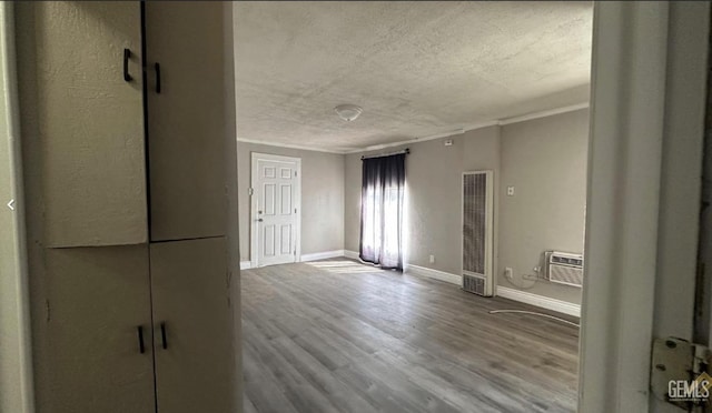 interior space featuring hardwood / wood-style floors, a textured ceiling, and a wall unit AC