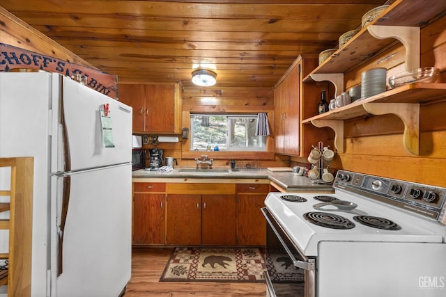 kitchen with white appliances, sink, wooden ceiling, light hardwood / wood-style floors, and wood walls