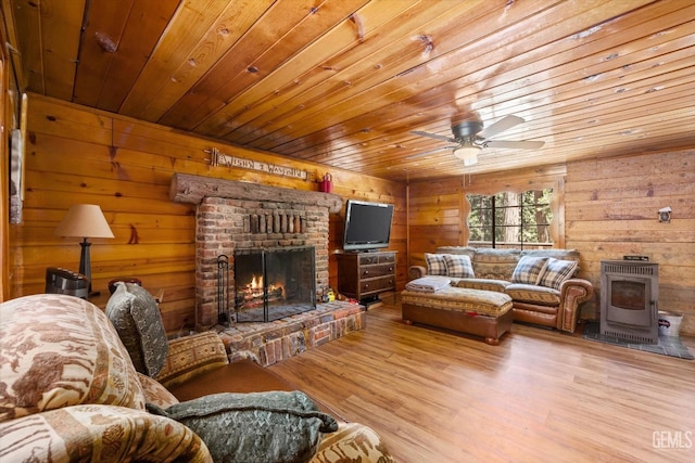 living room with ceiling fan, light wood-type flooring, wooden ceiling, and a fireplace