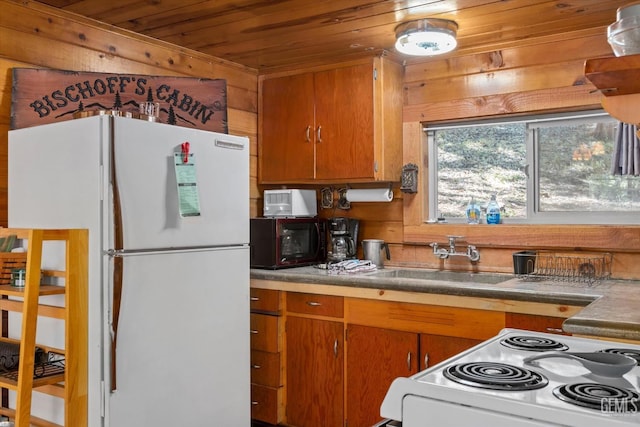 kitchen with wood walls, white appliances, sink, and wooden ceiling