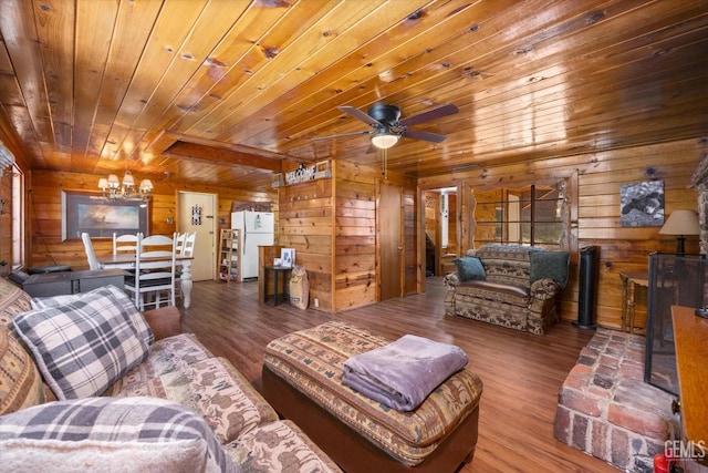 living room featuring ceiling fan with notable chandelier, wood walls, and wooden ceiling