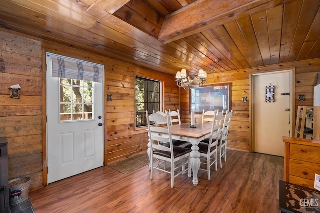 dining area with wood ceiling, wooden walls, wood-type flooring, beam ceiling, and a notable chandelier