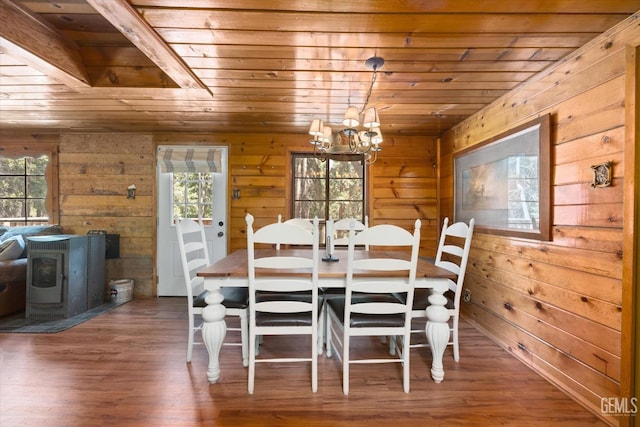 dining area featuring a wood stove, a wealth of natural light, wooden ceiling, and hardwood / wood-style flooring