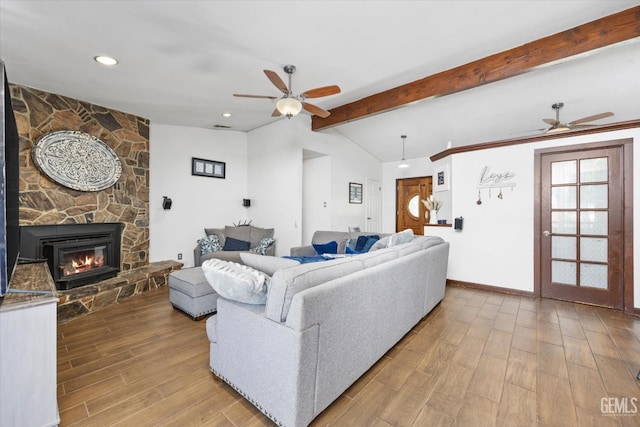 living room featuring ceiling fan, a fireplace, and lofted ceiling with beams