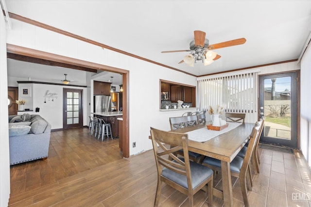 dining area with crown molding, ceiling fan, and wood-type flooring