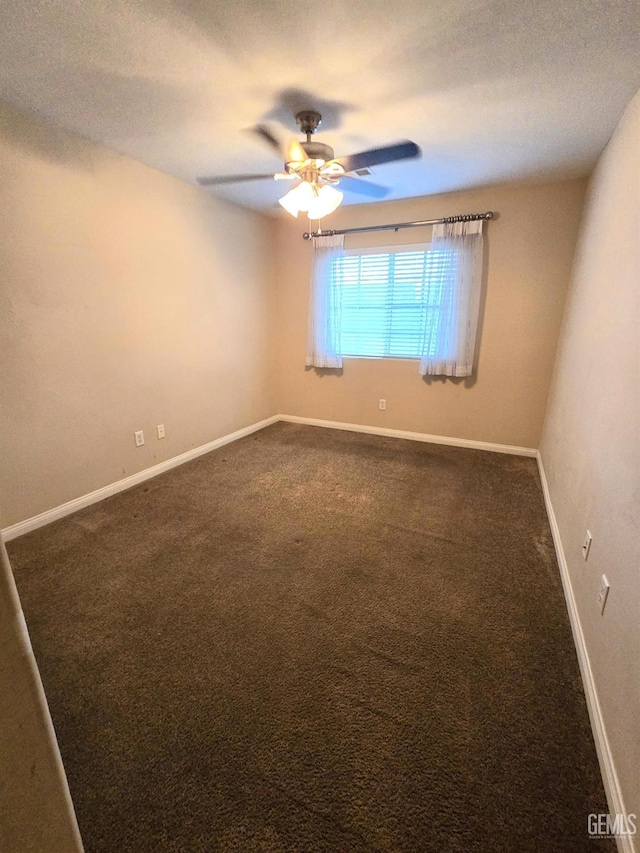 unfurnished room featuring dark carpet, a textured ceiling, baseboards, and ceiling fan