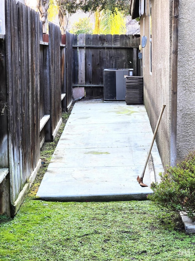 view of patio with fence, cooling unit, and a wooden deck