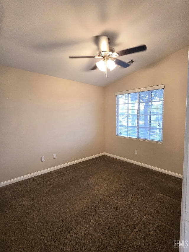 empty room featuring a ceiling fan, visible vents, vaulted ceiling, baseboards, and dark colored carpet