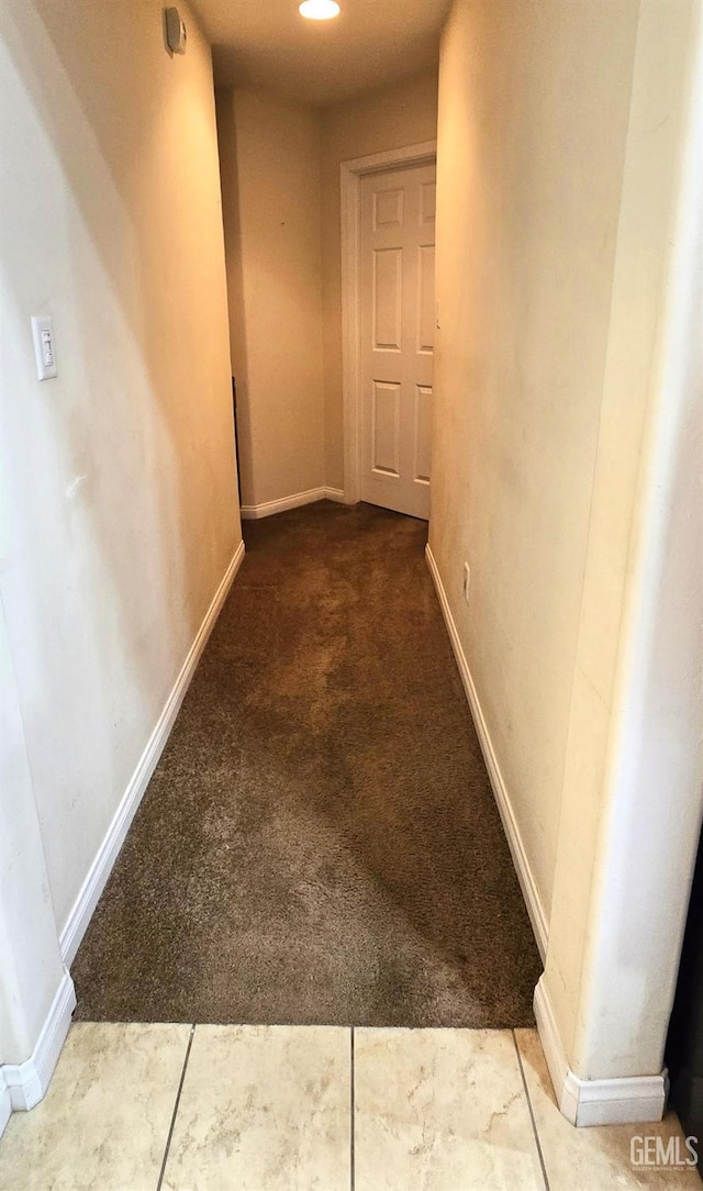 hall featuring carpet floors and baseboards