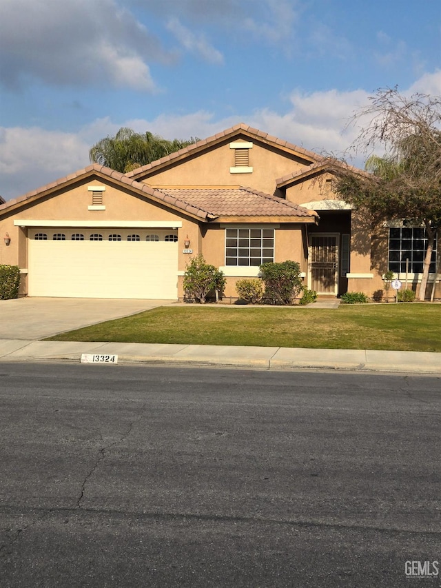 mediterranean / spanish-style house featuring a garage and a front lawn