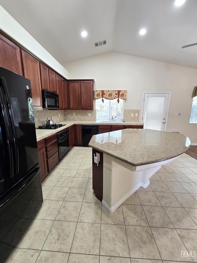 kitchen with light tile patterned floors, visible vents, lofted ceiling, light stone countertops, and black appliances