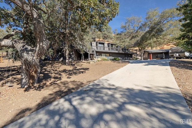 view of front of property featuring a wooden deck and concrete driveway