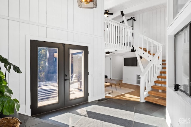 interior space with stairway, ceiling fan, french doors, and beam ceiling