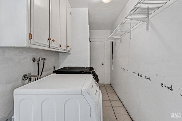3304 Charlotte St, Bakersfield, CA 93313 - washroom featuring washing machine and clothes dryer, cabinet space, and light tile patterned floors
