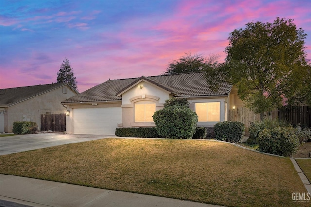 view of front of home with a garage and a lawn