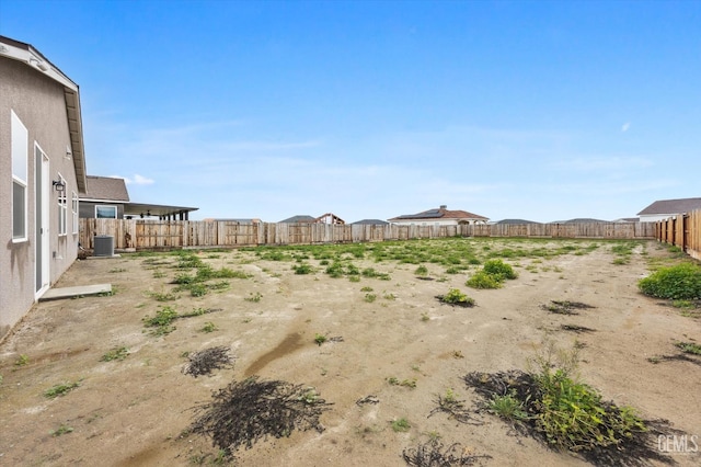 view of yard with cooling unit and a fenced backyard