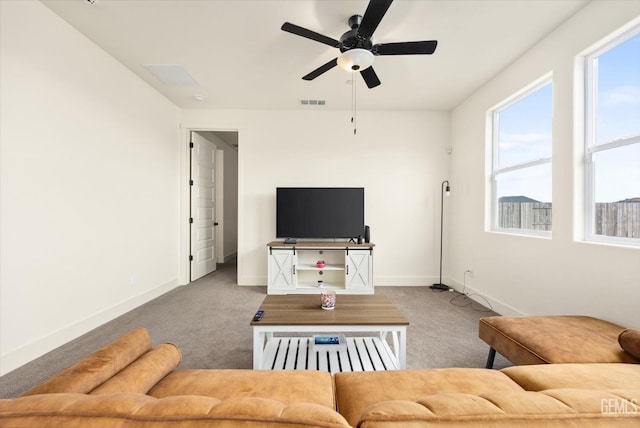 carpeted living room featuring visible vents, a ceiling fan, and baseboards