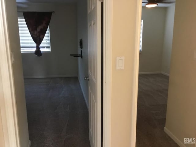 hall with dark colored carpet