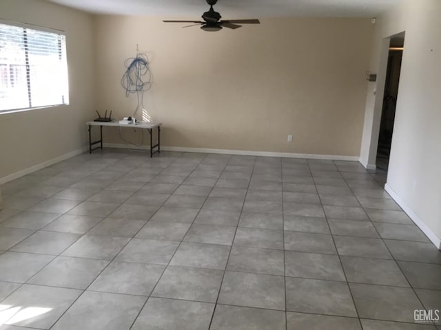 tiled empty room featuring ceiling fan