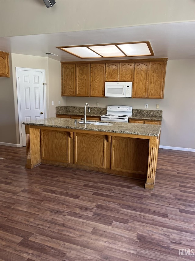 5700 Via Marisol St, Bakersfield, CA 93308 - kitchen with white appliances, dark wood-type flooring, stone counters, brown cabinetry, and a kitchen island with sink