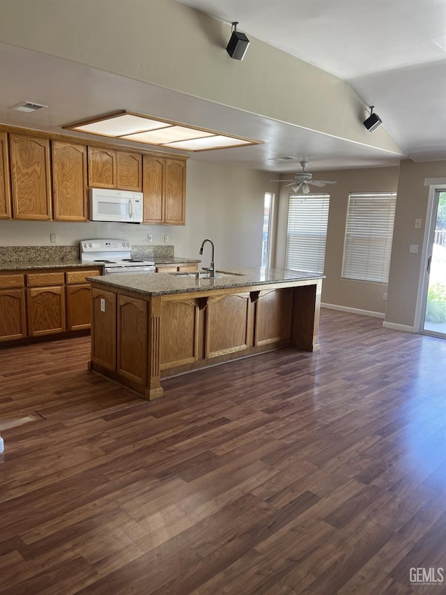 5700 Via Marisol St, Bakersfield, CA 93308 - kitchen featuring white appliances, vaulted ceiling, brown cabinetry, a center island with sink, and dark wood-type flooring