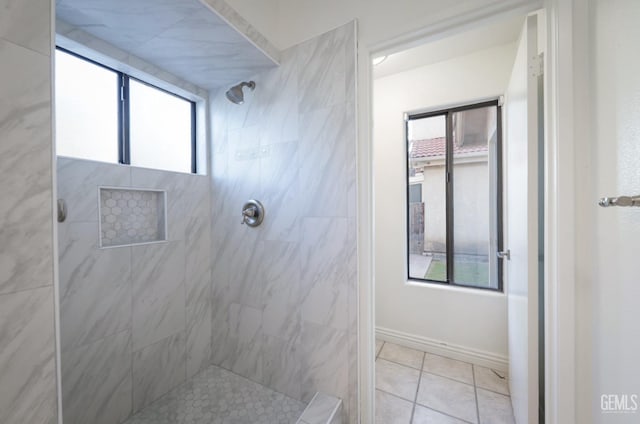 bathroom with a tile shower and tile patterned flooring