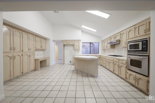 kitchen with tasteful backsplash, vaulted ceiling, a center island, light tile patterned flooring, and stainless steel appliances