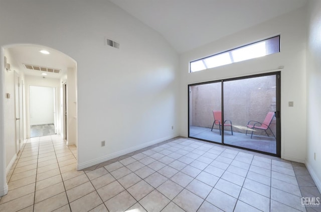 tiled empty room with vaulted ceiling