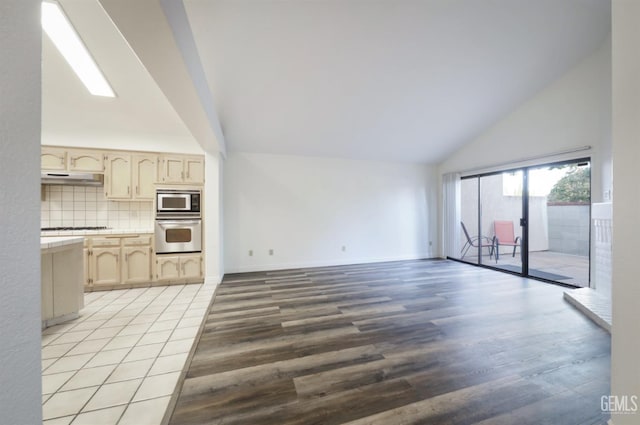 unfurnished living room featuring high vaulted ceiling and light wood-type flooring