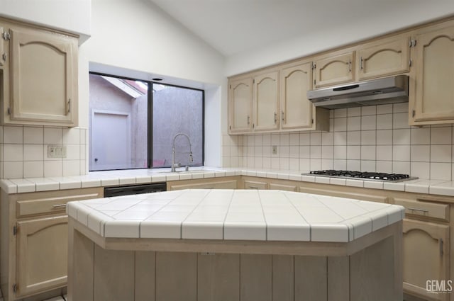 kitchen with a center island, lofted ceiling, and tile countertops