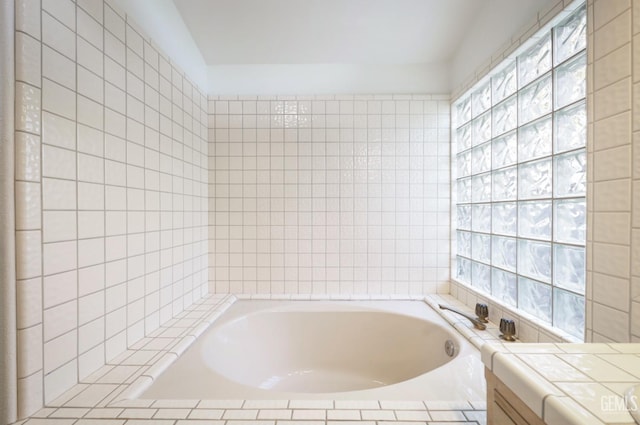 bathroom featuring vanity, tile walls, and a relaxing tiled tub