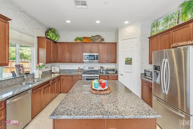 9803 Petersburg Pl, Bakersfield, CA 93306 - kitchen featuring appliances with stainless steel finishes, a center island, light stone counters, a sink, and recessed lighting