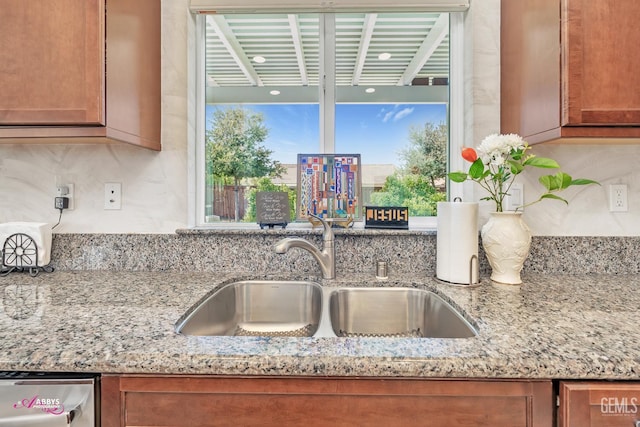 9803 Petersburg Pl, Bakersfield, CA 93306 - kitchen with a sink, brown cabinets, tasteful backsplash, and light stone countertops