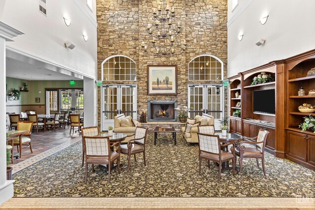 9803 Petersburg Pl, Bakersfield, CA 93306 - living area with a high ceiling, a stone fireplace, and a chandelier