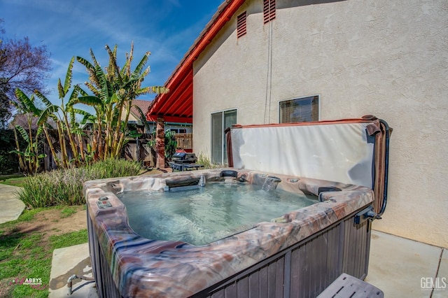 exterior space with fence and a hot tub