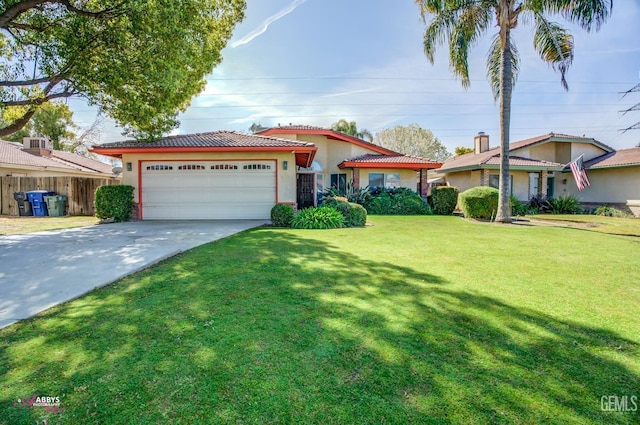 view of front of house featuring stucco siding, driveway, fence, a front yard, and an attached garage