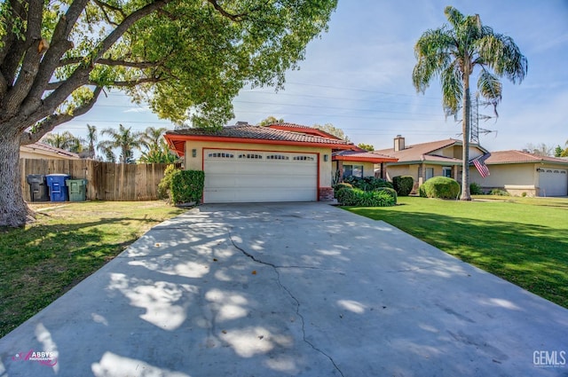 view of front of property featuring a front lawn, fence, concrete driveway, stucco siding, and a garage