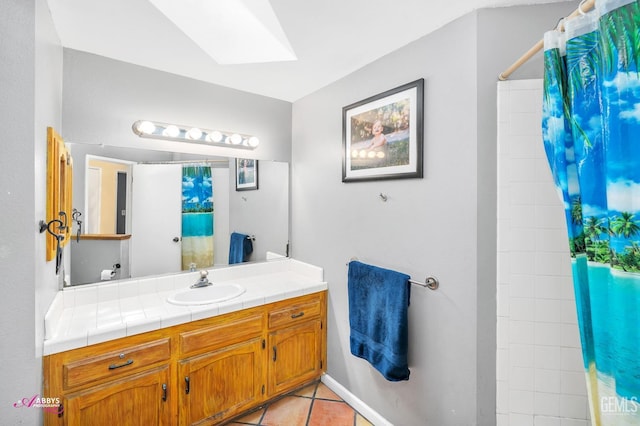 full bathroom with tile patterned flooring, curtained shower, a skylight, and vanity