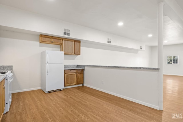 kitchen with light hardwood / wood-style floors and white appliances