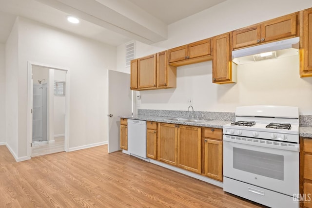 kitchen featuring light stone counters, white appliances, sink, and light hardwood / wood-style flooring