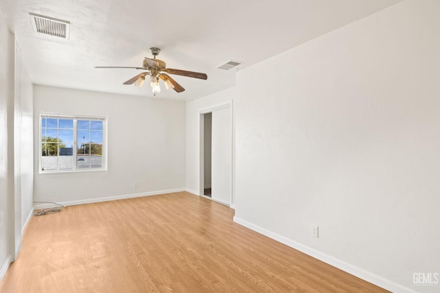 spare room with light wood-type flooring and ceiling fan