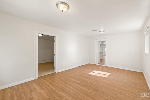 unfurnished bedroom featuring a spacious closet, a closet, and light wood-type flooring