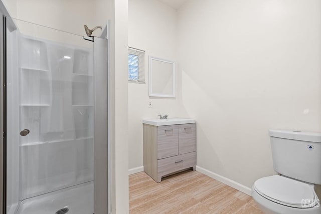 bathroom featuring walk in shower, hardwood / wood-style flooring, vanity, and toilet