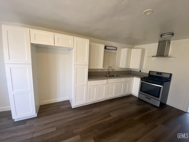 kitchen featuring dark hardwood / wood-style flooring, sink, white cabinets, stainless steel gas stove, and wall chimney range hood