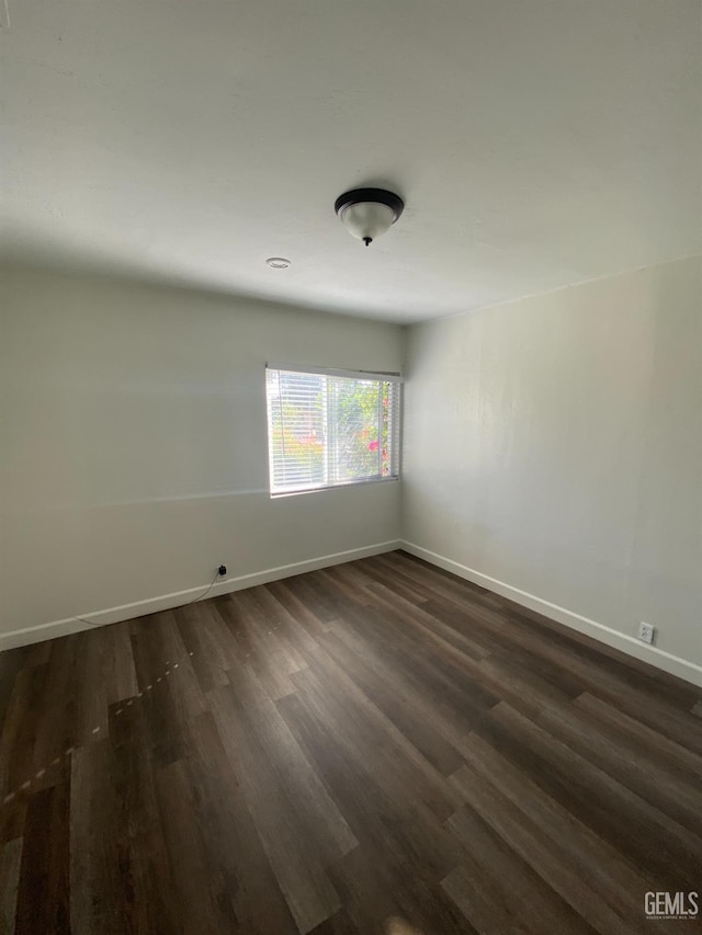 spare room featuring dark wood-type flooring