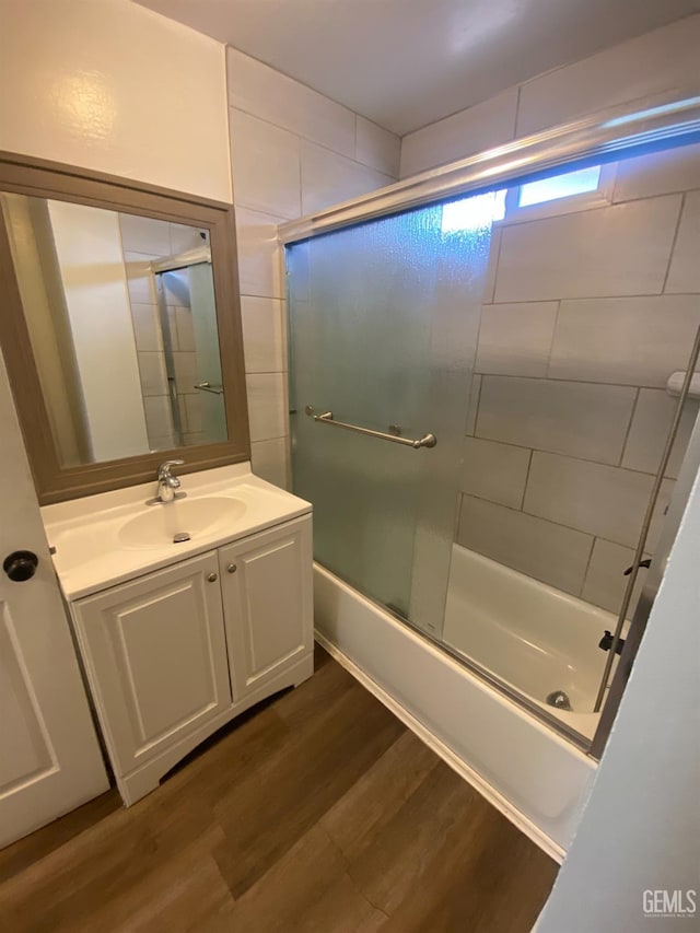 bathroom featuring combined bath / shower with glass door, wood-type flooring, and vanity