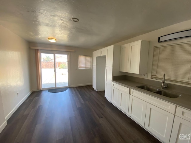 kitchen with dark hardwood / wood-style floors, white cabinetry, and sink