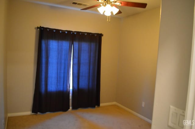 spare room featuring ceiling fan, carpet floors, visible vents, and baseboards