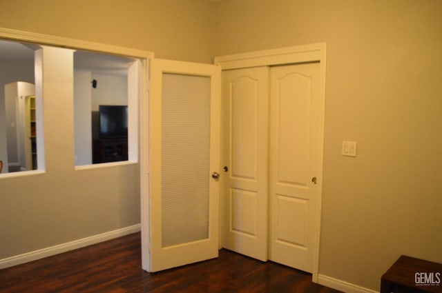 unfurnished bedroom featuring dark wood-style floors and baseboards