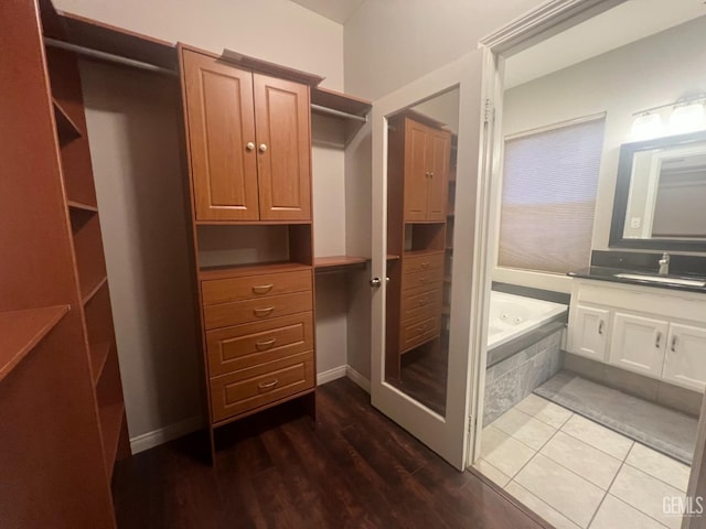 bathroom featuring vanity, a tub with jets, and wood finished floors